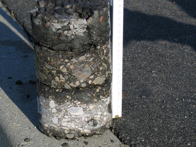 Ein Bohrkern auf der Straße mit Meterstab