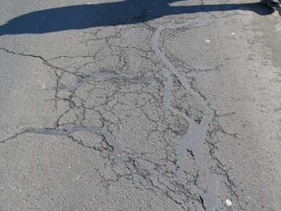 Schadensbild Straße mit Personenschatten